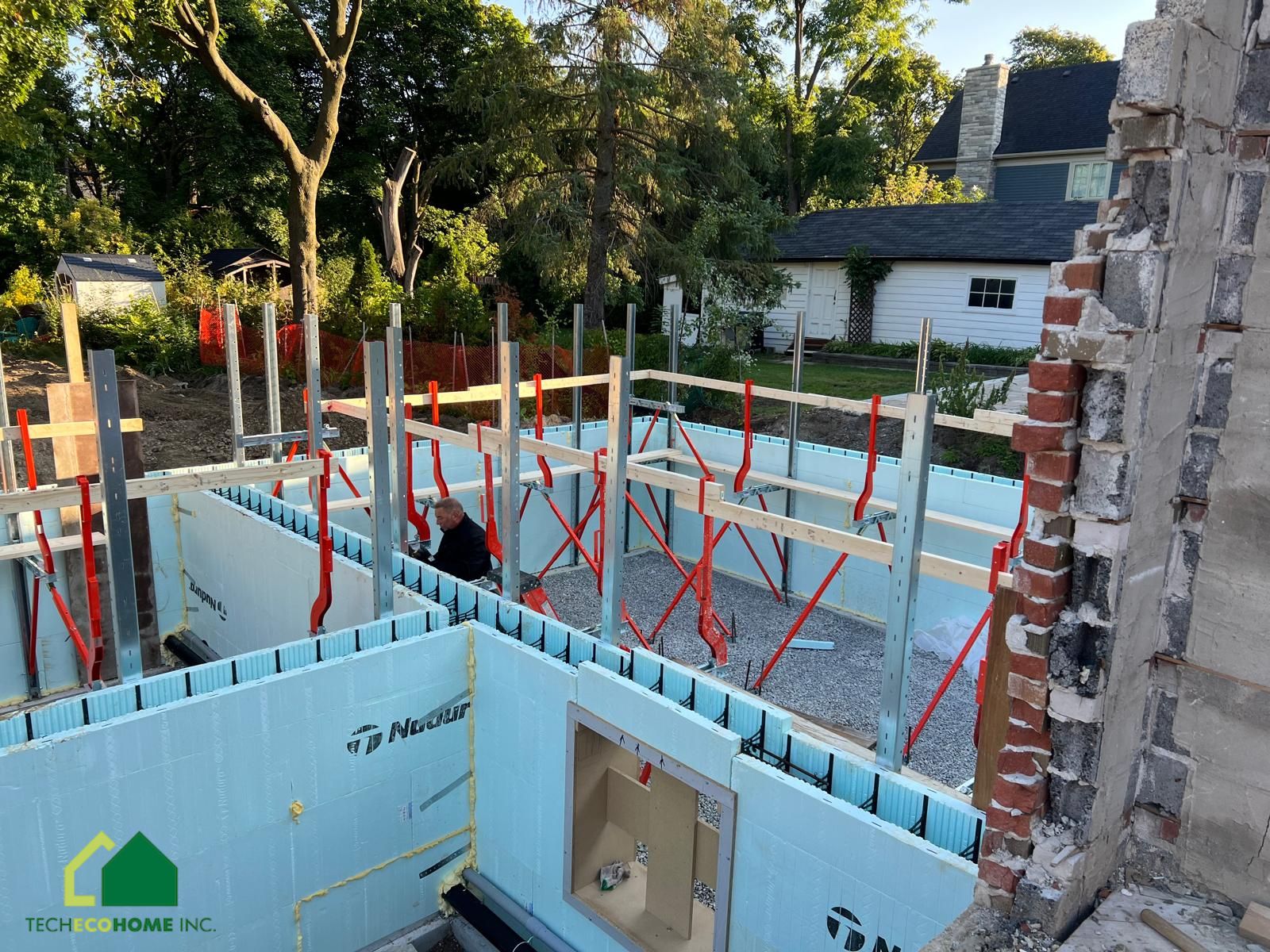 TECHECOHOME crew stacking and bracing ICF basement walls with window bucks on a residential site